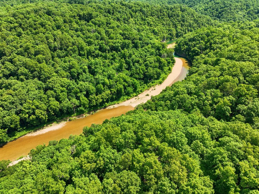 Aerial view of an Ozark river winding through summer forest